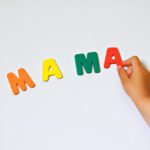 A child holding letters that spell out mama.