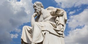 A statue of socrates is shown in front of the sky.