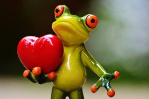 A frog holding a heart in his hands.