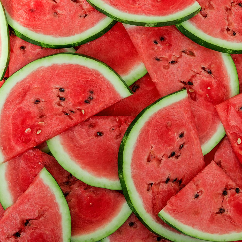A close up of sliced watermelon on top of a table.