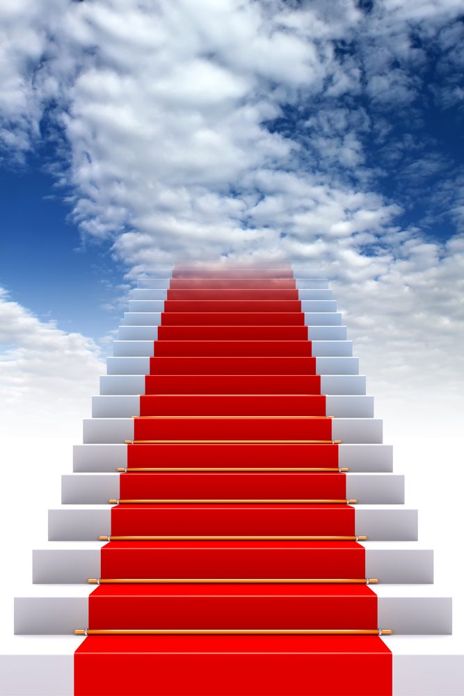 A red carpet on top of steps leading to the sky.