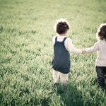 Children holding hands in grass field