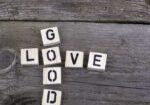 A wooden table with the word good spelled out in scrabble tiles.