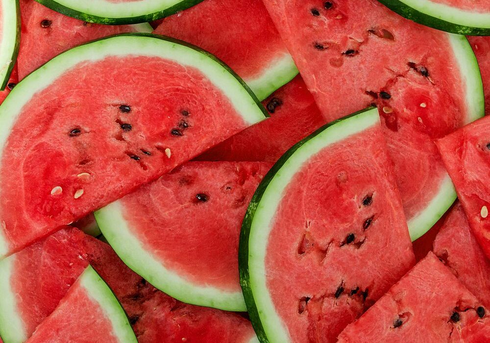 A close up of sliced watermelon on top of a table.