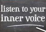 A chalkboard with the words listen to your inner voice written on it.