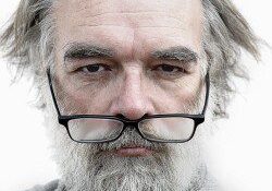 A man with long grey hair and glasses.