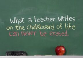 A chalkboard with an apple and some writing on it