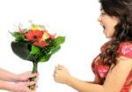 A woman is giving flowers to someone else